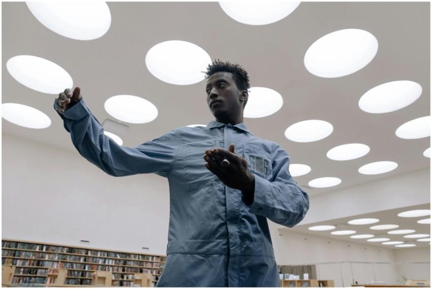 A young man dancing in a stylish library with uniq