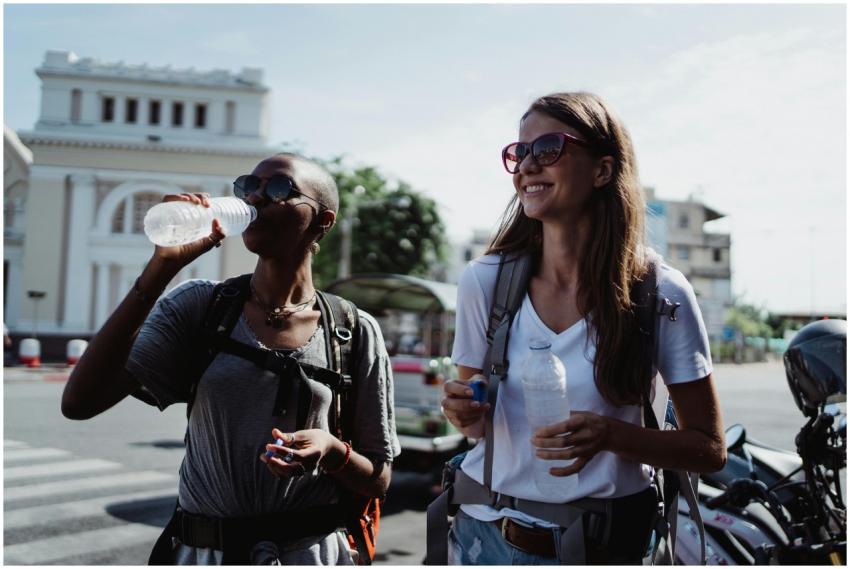 Two women backpackers sipping water while explorin