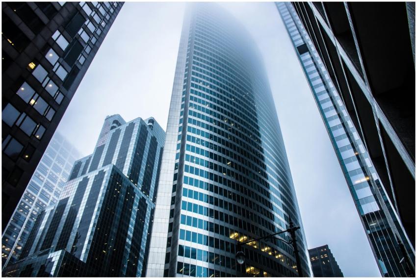 Dramatic view of modern skyscrapers shrouded in fo