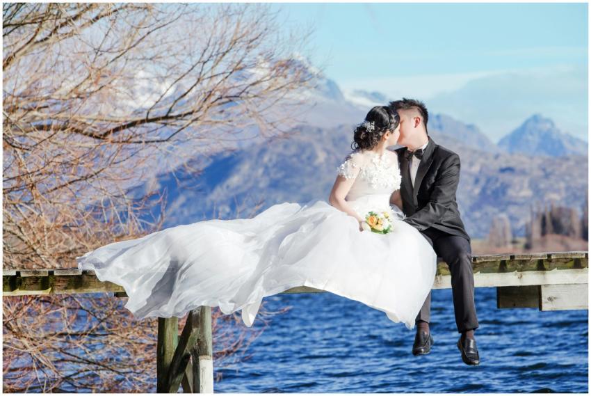 Beautiful wedding couple in love kissing on a dock
