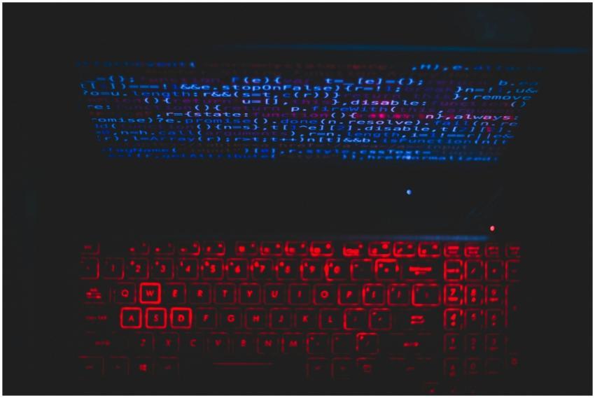 Dark-themed laptop setup with a red glowing keyboa