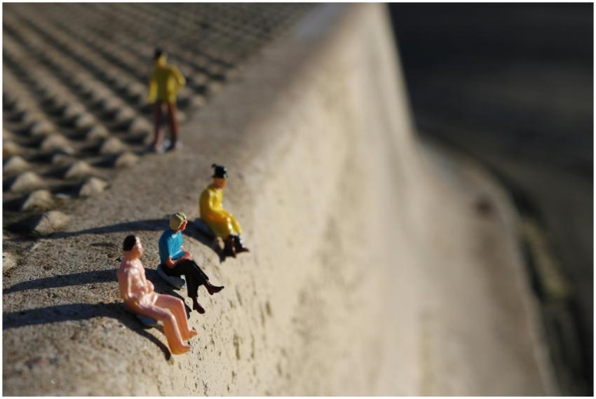Tiny figurines arranged on concrete, highlighting