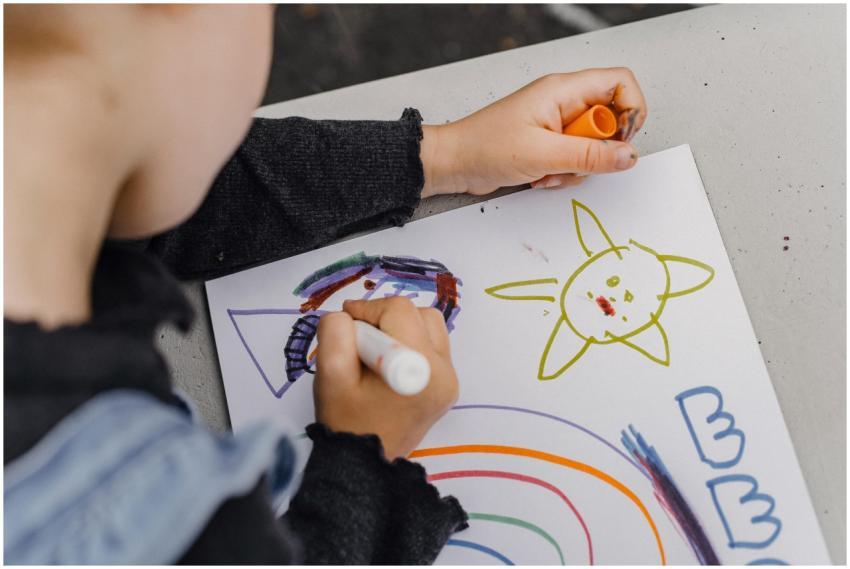 High angle of crop unrecognizable kid sitting at t