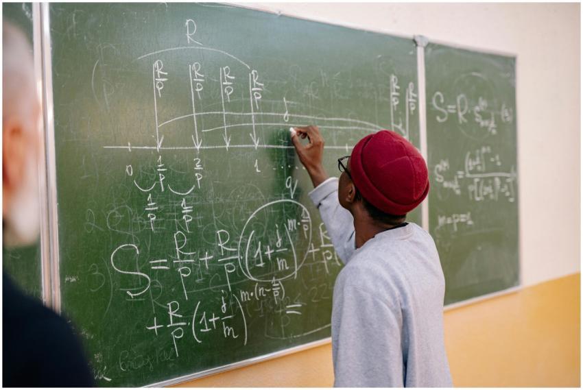 A young student writes mathematical equations on a
