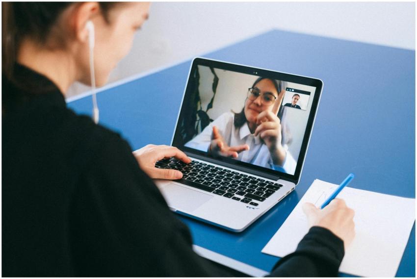 Woman participating in a virtual meeting, taking n