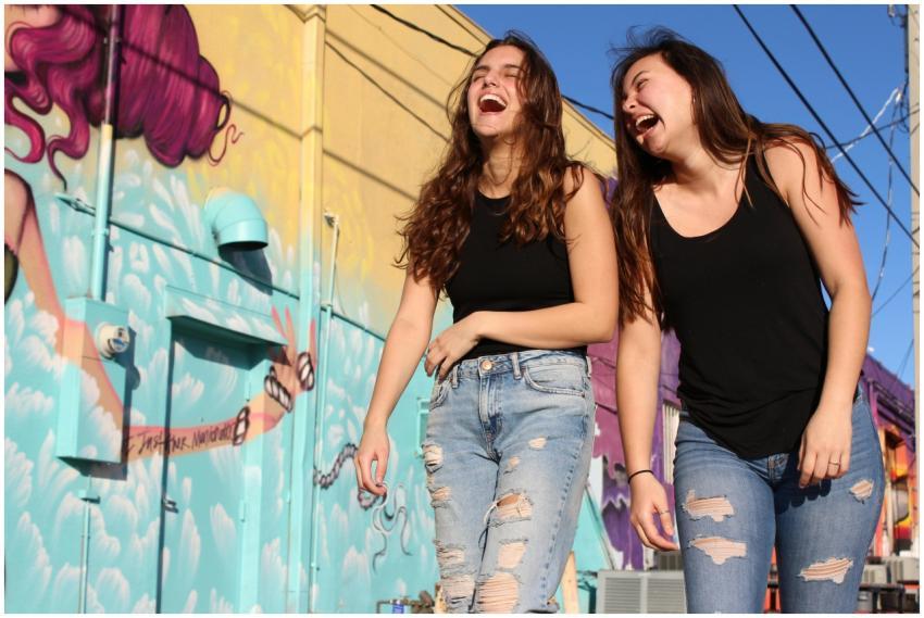 Two women laughing and enjoying a sunny day by a v