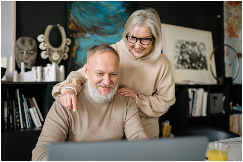 A happy elderly couple wearing sweaters, smiling w