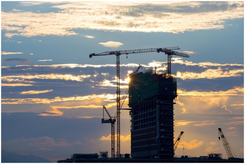 Silhouette of cranes and a building under construc