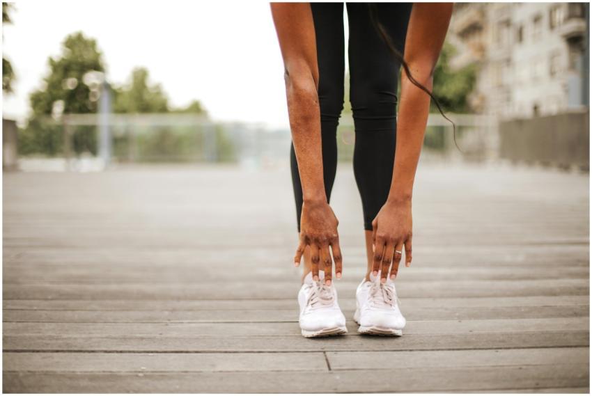 From below crop slender female athlete in sportswe