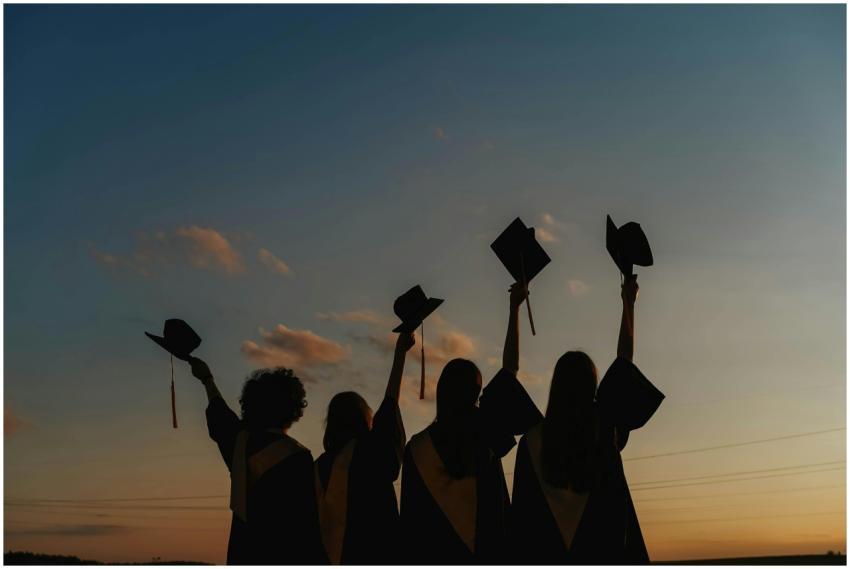A group of graduates celebrate by raising their ca
