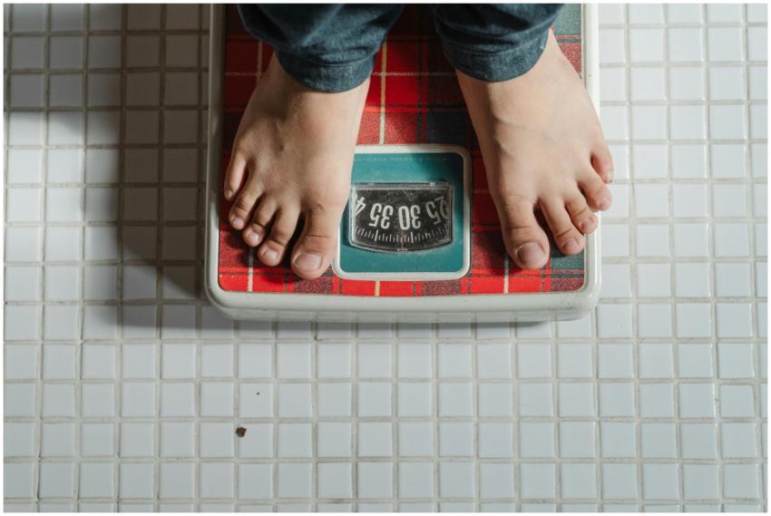 From above crop anonymous barefoot child in jeans