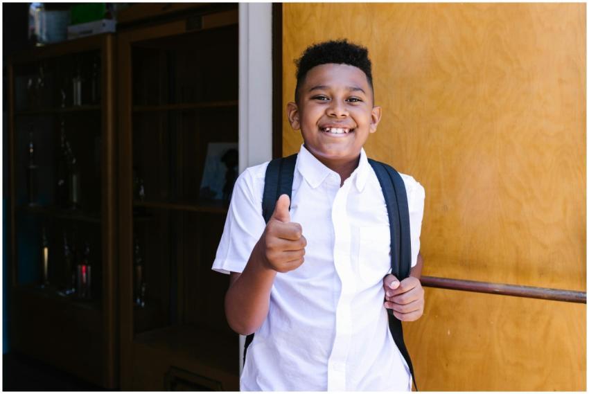 Smiling student with backpack giving thumbs up, st