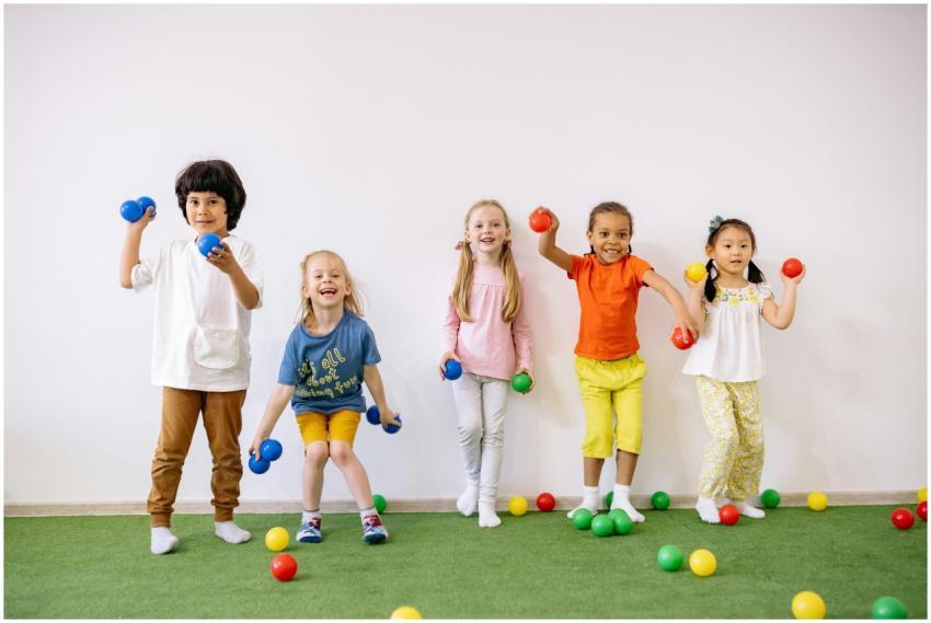 Happy diverse children playing with colorful balls