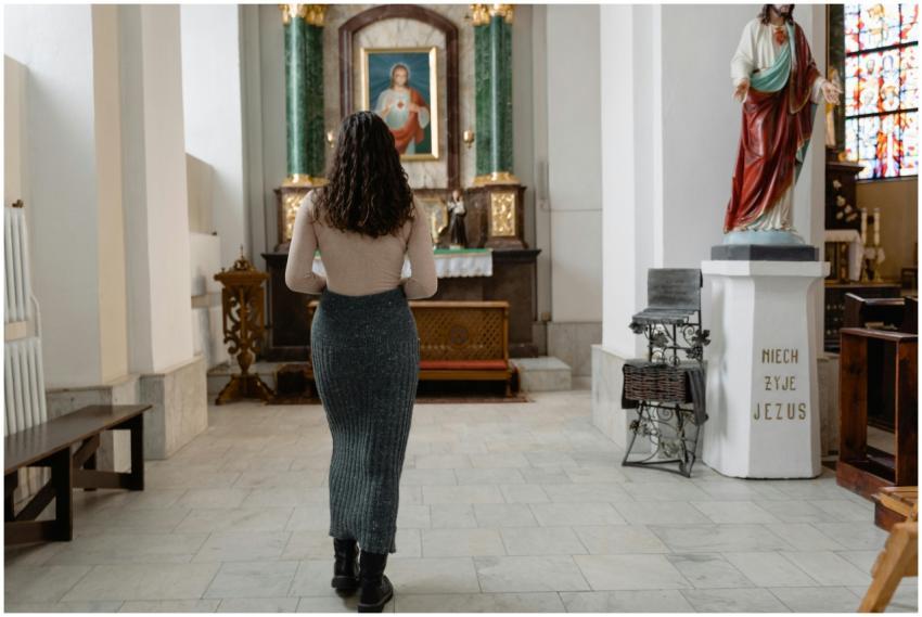 A woman in a church stands before an altar, surrou