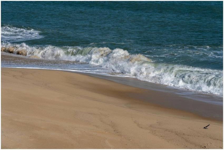 A serene scene of waves gently crashing onto a san