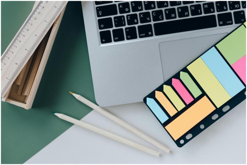 Organized desk with a laptop, sticky notes, pencil