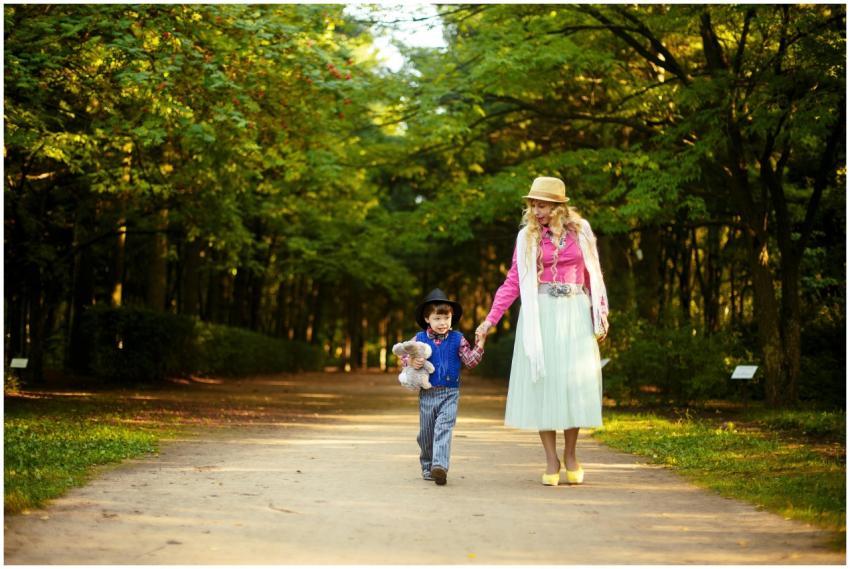 A cheerful mother and son enjoy a walk in a sunlit