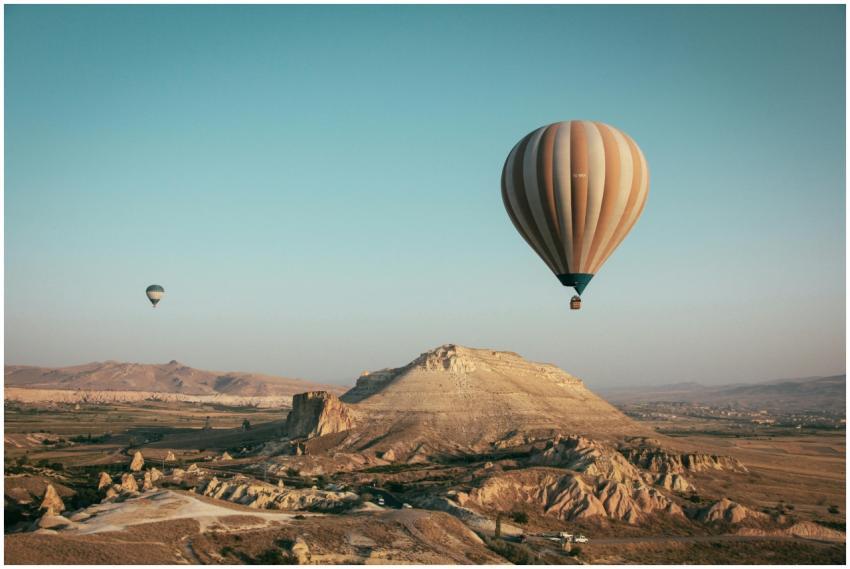 Hot air balloons float over the mesmerizing landsc