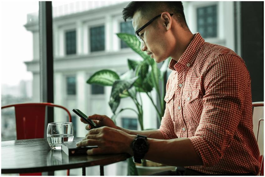 A young man uses his smartphone in a modern indoor