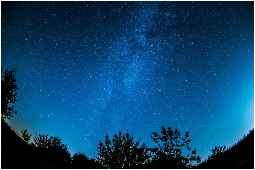 A breathtaking view of a starry night sky over a s