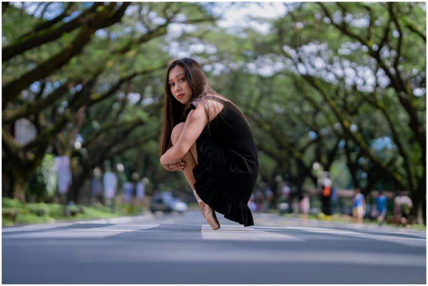 Elegant ballerina in black dress posing on a sceni