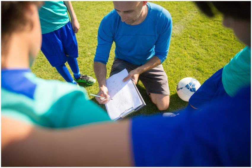 Coach instructing young soccer players during a pr