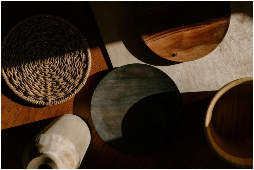 A flat lay of wooden kitchen utensils and woven ma