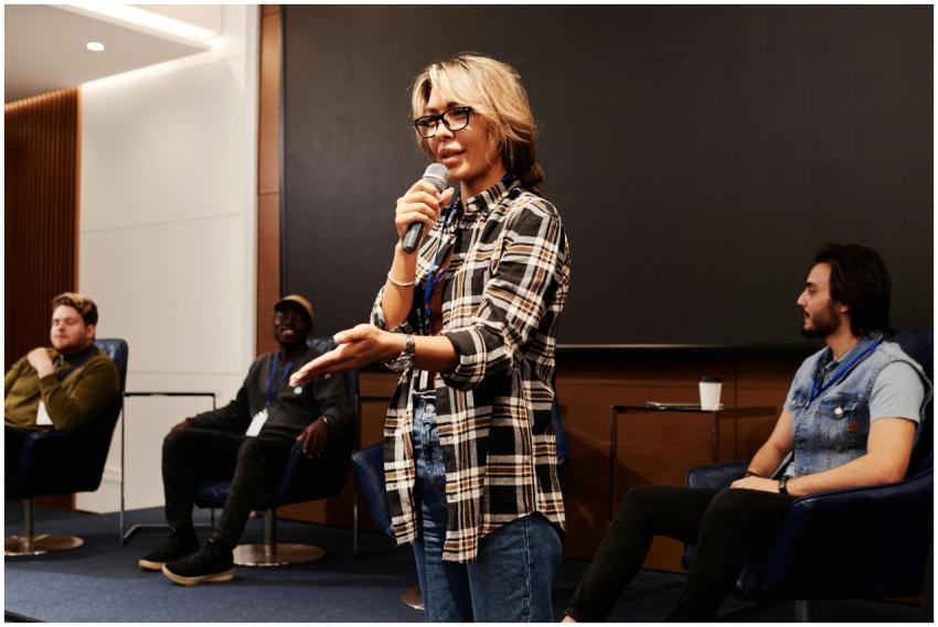 A confident woman speaks into a microphone during