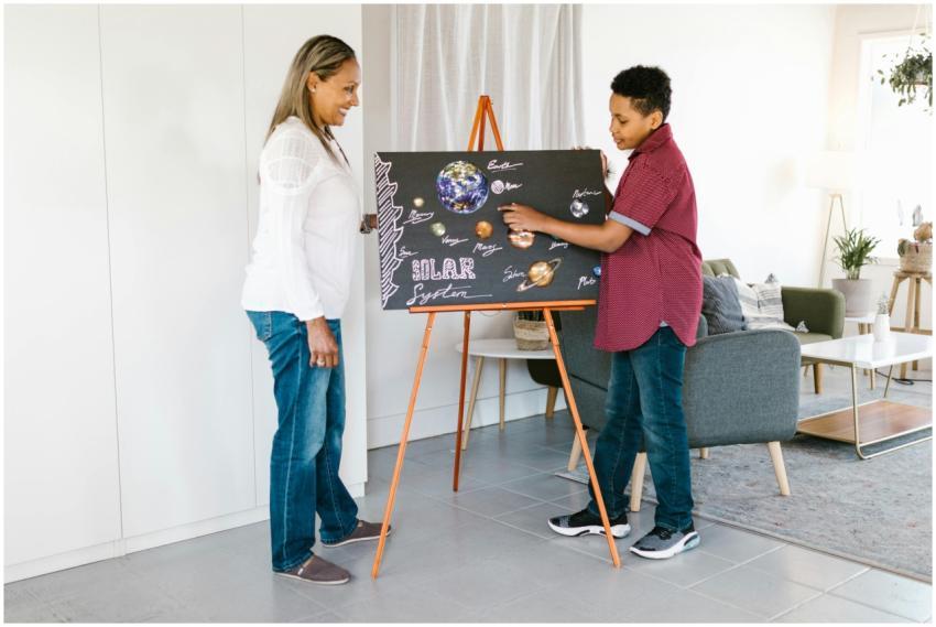 Woman and boy learning about the solar system usin