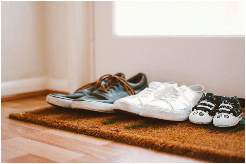 Cozy family shoes on a doormat at home entrance, s