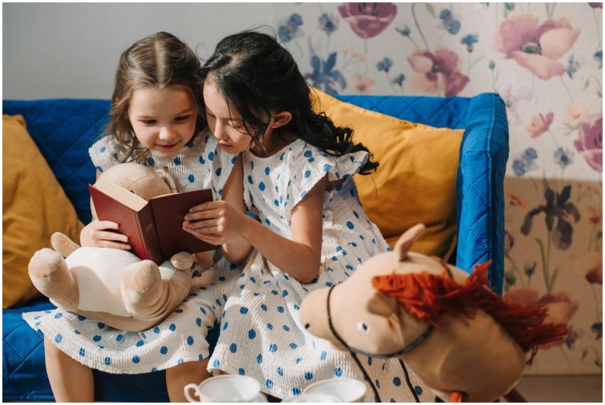 Two young girls in polka dot dresses happily readi