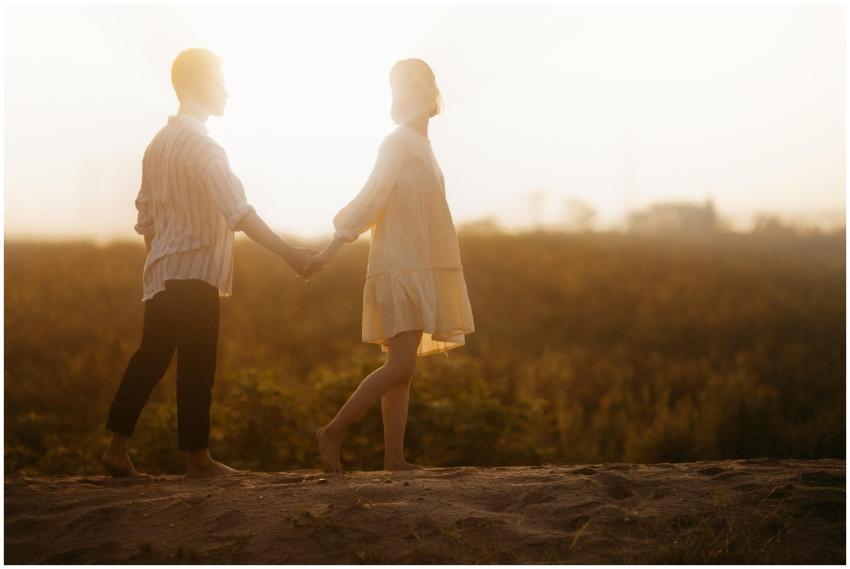 A loving couple holding hands during a sunset walk