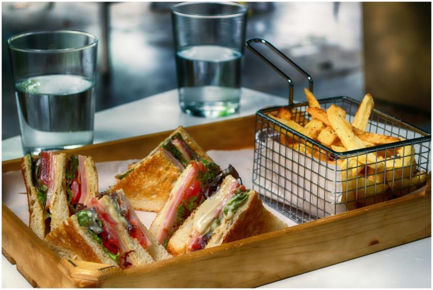 Tasty club sandwich and crispy fries served with g