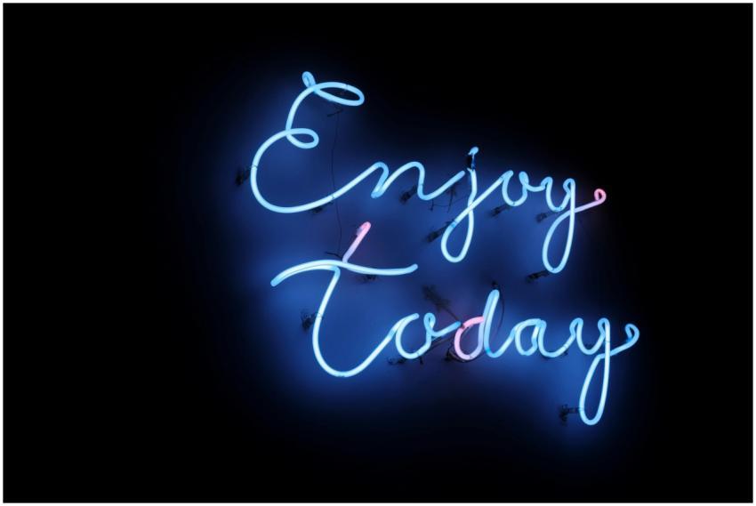 Bright blue neon sign with the phrase 'Enjoy Today