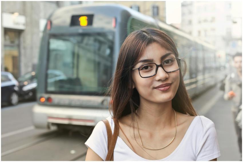Young woman smiling in front of a tram in Milan, I