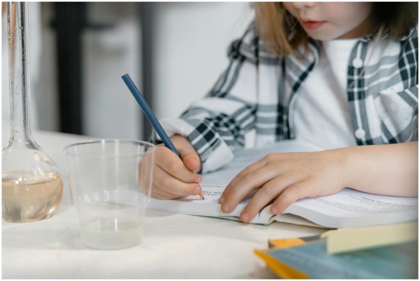 Young child learning science, writing surrounded b