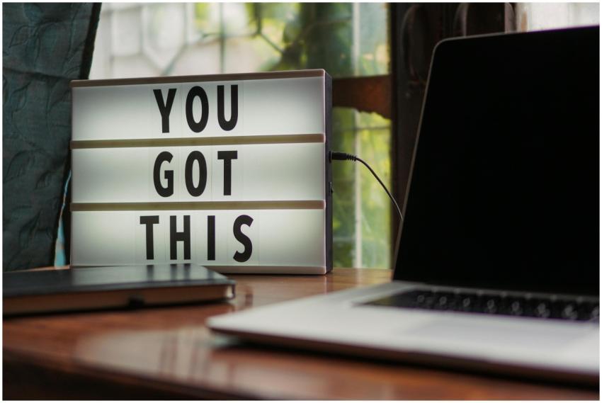 Lit sign with 'You Got This' alongside laptop on o