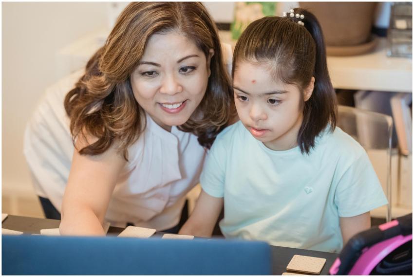 A woman and young girl using a computer together,