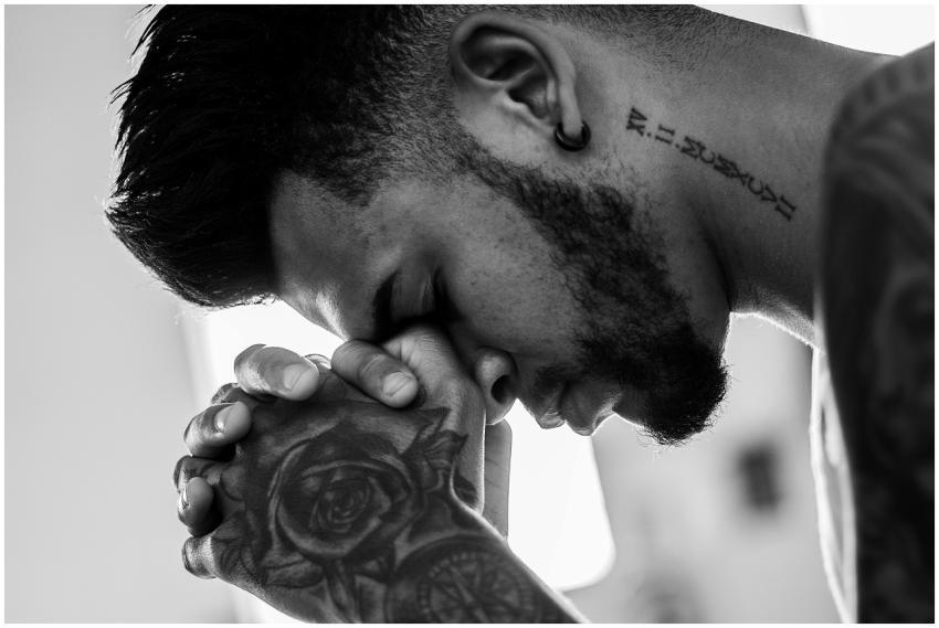 A man in deep thought and prayer, showcasing tatto