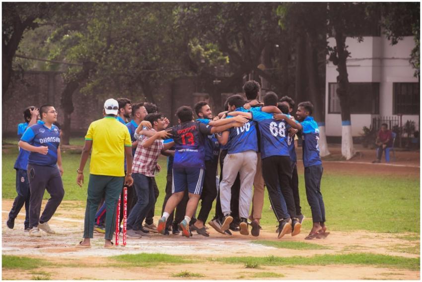 Excited group of male cricket players celebrate a