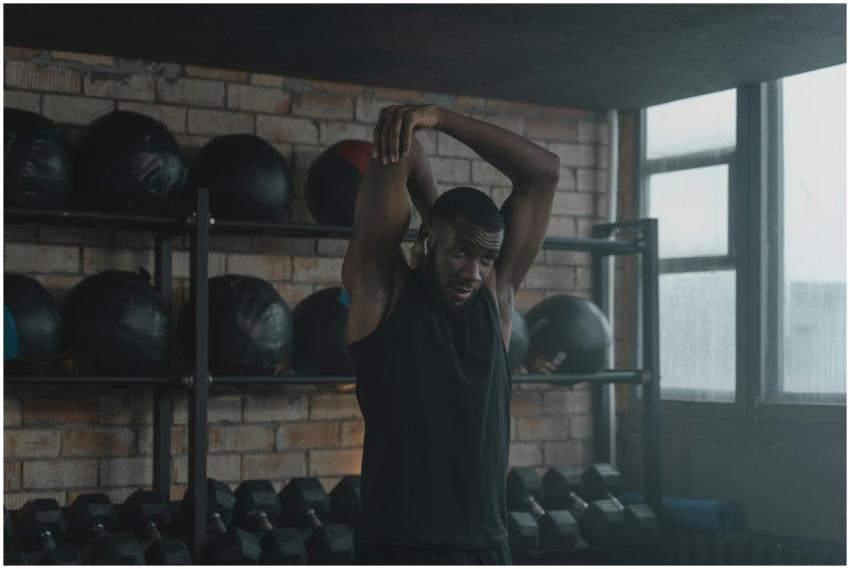 Black man performing an overhead tricep stretch in