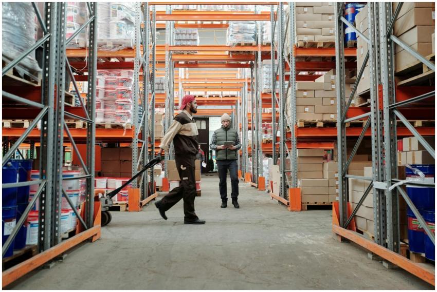 Two workers manage inventory in a spacious warehou