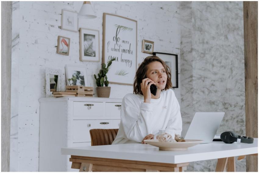Woman in stylish home office using smartphone and