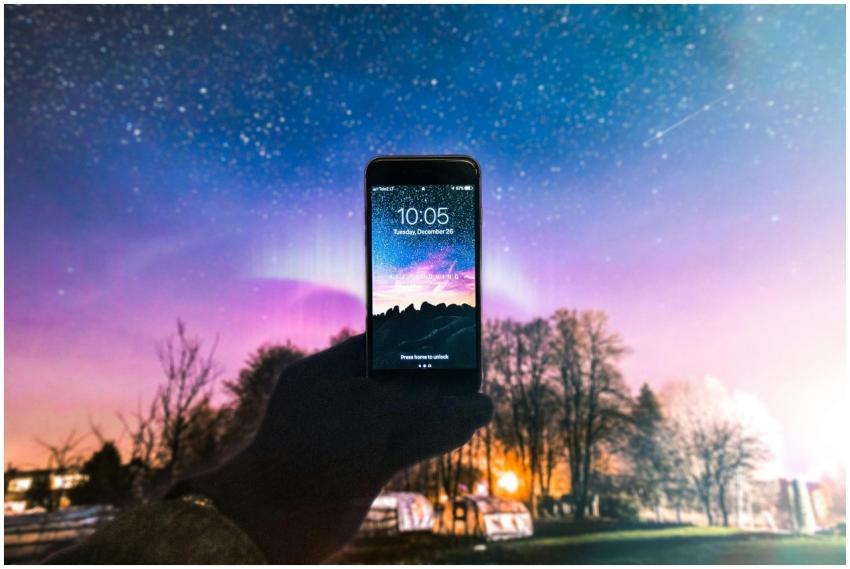 A smartphone displaying the night sky held against