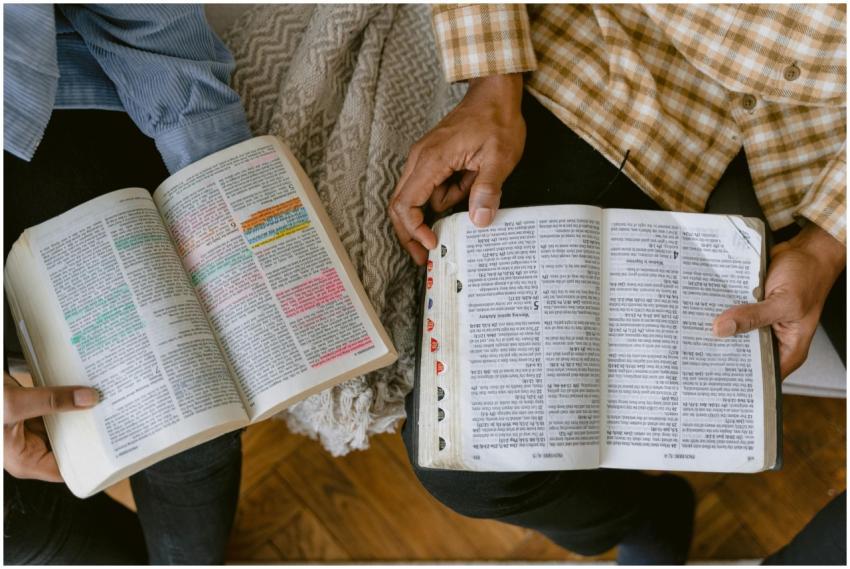 Two adults reading religious texts with highlighte