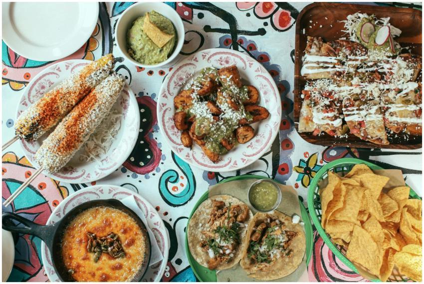 Vibrant Mexican meal featuring tacos, elote, nacho