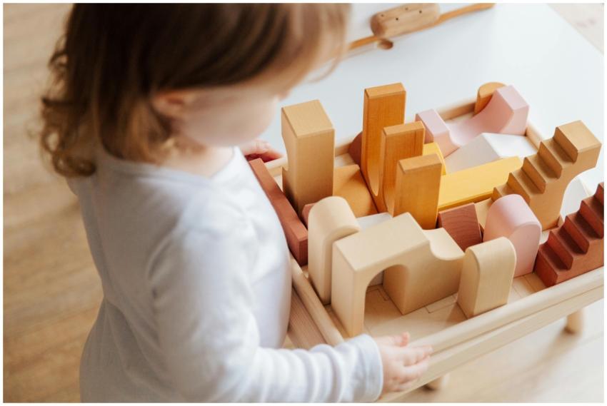 A child engaged in play with wooden blocks on a ta