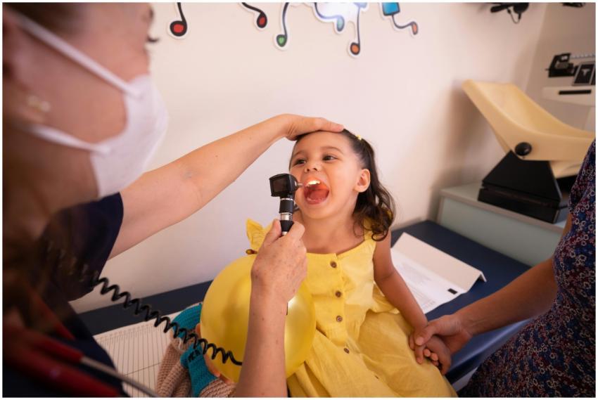 Pediatrician examines smiling child in a health cl