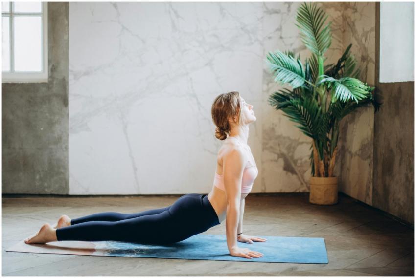Woman in yoga pose on mat, exercising indoors with