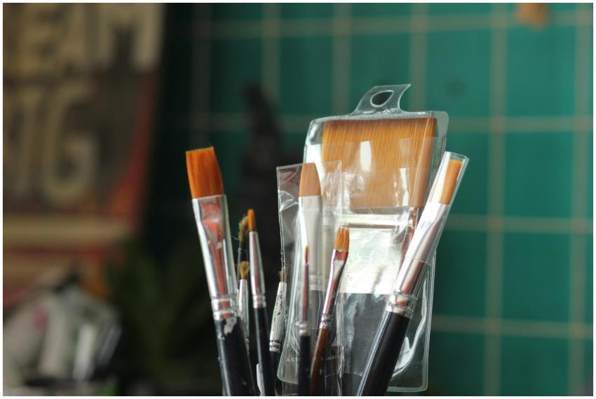 A collection of new paint brushes in a plastic con